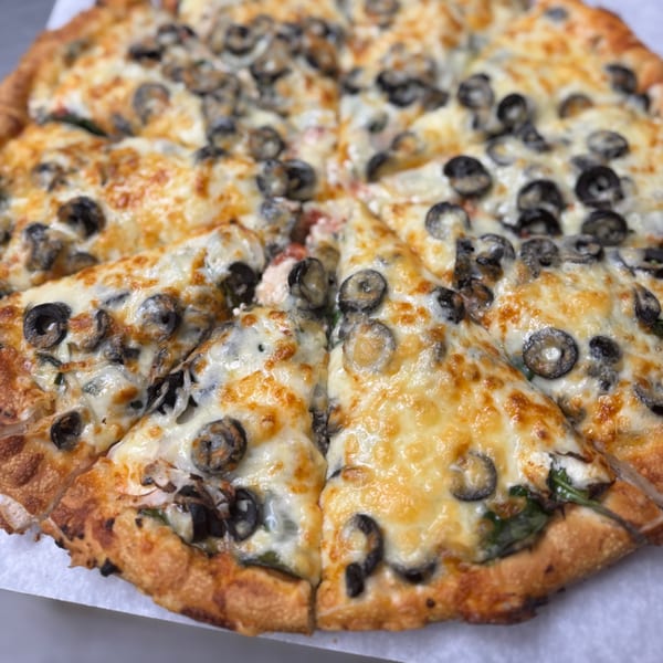 Milano's Pizza with melted cheese and sliced black olives, cut into individual slices.
