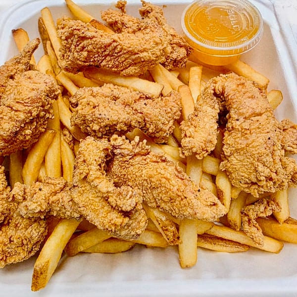 Crispy fried chicken tenders and golden french fries in a white container with a side of sauce.